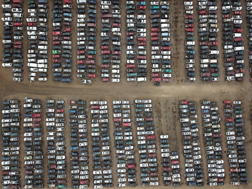 Aerial photo of a large parking lot filled with rows of diverse vehicles.
