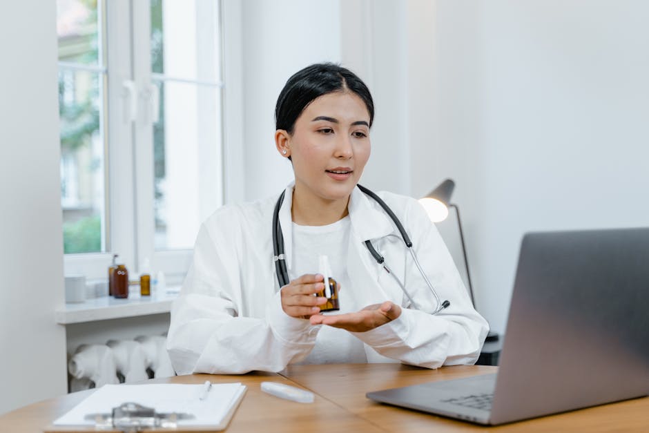 A young female doctor in a white coat on a video call, discussing medication with a patient
