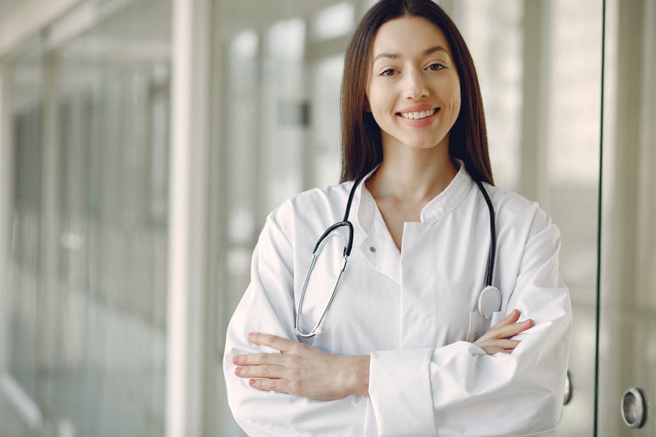 Portrait of a smiling female doctor with arms crossed and stethoscope in a hospital corridor