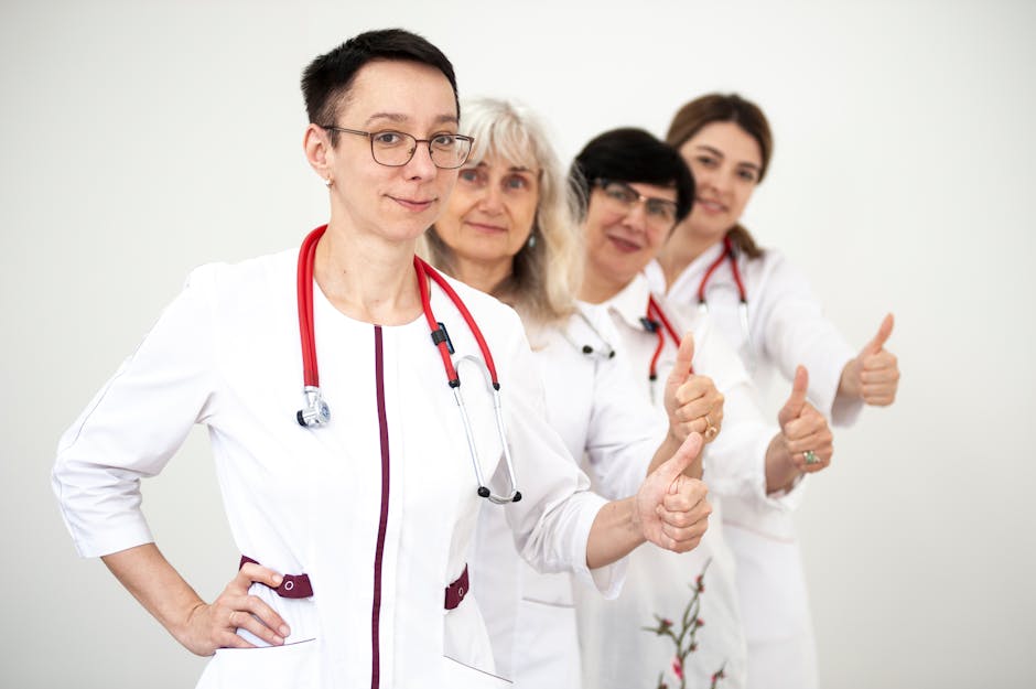 A group of female doctors in white coats showing thumbs up, symbolizing teamwork and women empowerment in healthcare
